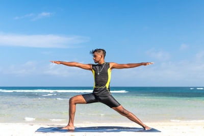 男子站在海边练瑜伽